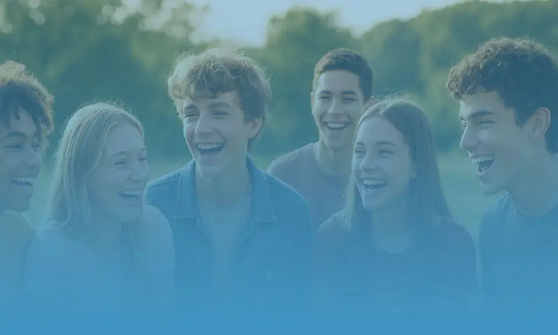 Group of teens laughing together outdoors while building friendship and emotional support